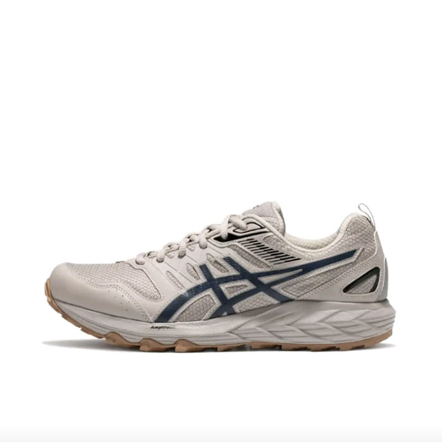 Beige sneaker with dark blue logo, textured mesh upper, and tan sole on a white background.