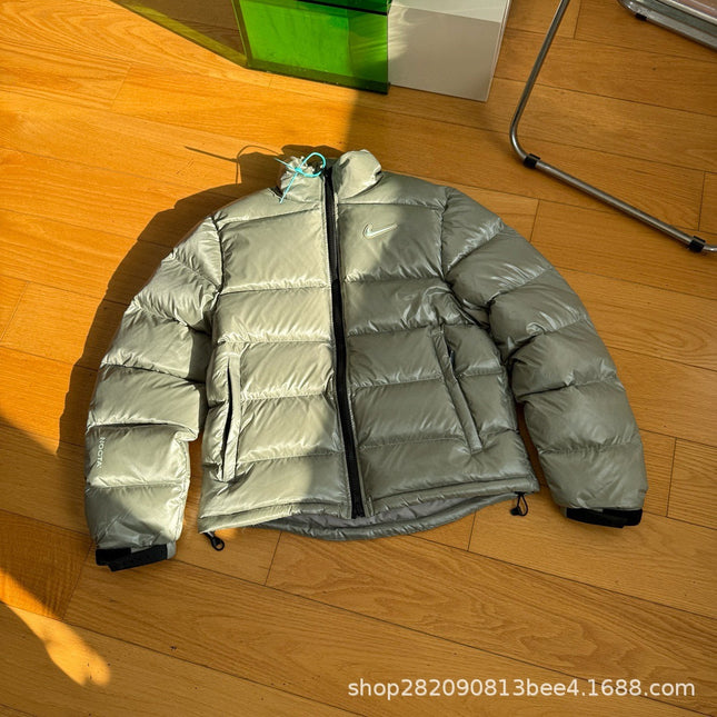 Die neue Winterjacke aus der Nocta-Serie mit kleinem Haken, in Zusammenarbeit mit Wang Yibo entstanden, ist eine lässige, lockere Daunenjacke für Paare.