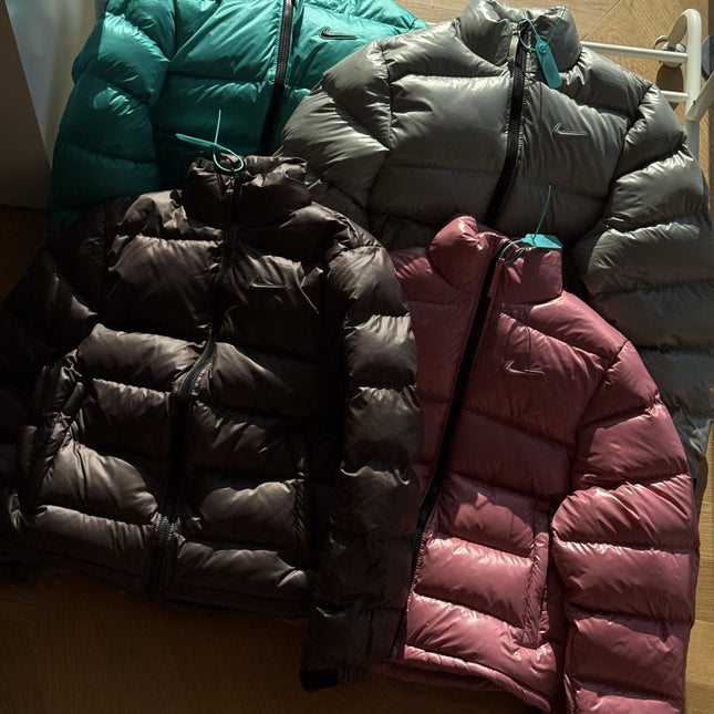 Die neue Winterjacke aus der Nocta-Serie mit kleinem Haken, in Zusammenarbeit mit Wang Yibo entstanden, ist eine lässige, lockere Daunenjacke für Paare.