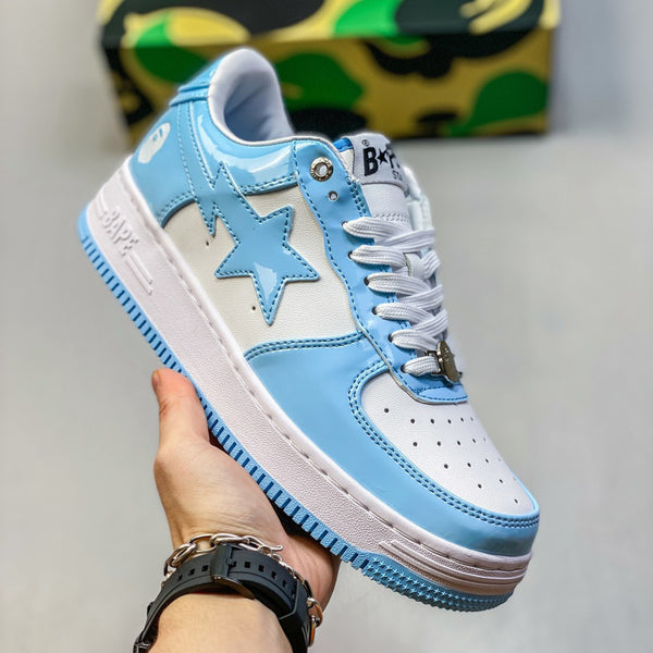 Blue and white sneaker with star design held by a hand against a neutral background